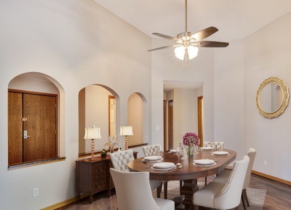 a dining room with a table and chairs and a ceiling fan