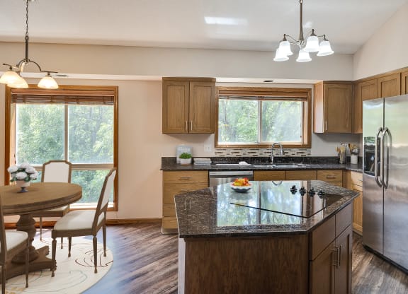 a kitchen with a island and a dining room with a table and chairs