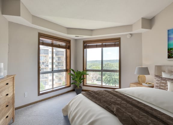 the master bedroom has a large window and a comfy bed