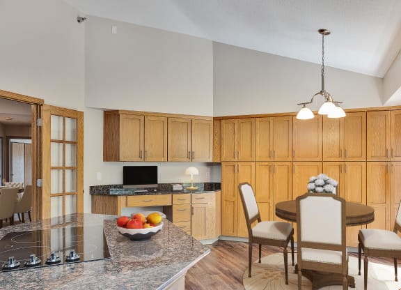 a kitchen and dining room with wooden cabinets and a granite counter top