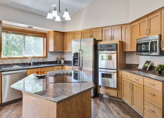 an updated kitchen with stainless steel appliances and granite counter tops