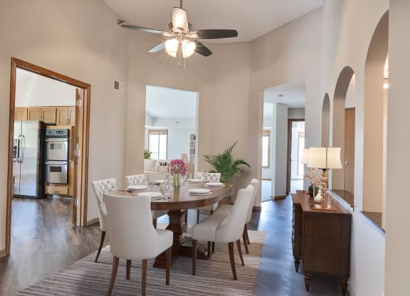 a dining room with a table and chairs and a ceiling fan