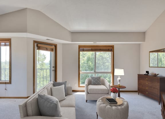 a living room with a couch and a chair and a window