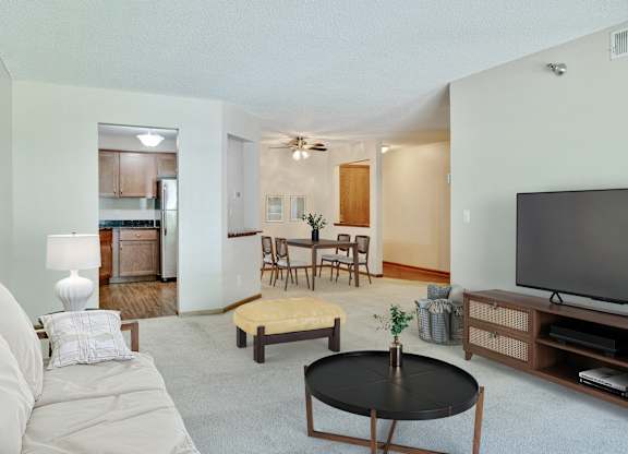 A living room with a couch, coffee table, and television at Crosby Pointe Apartments, Minnesota, 55116-3244