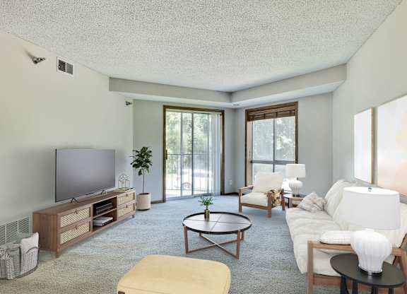 A living room with a television, couch, and coffee table. at Crosby Pointe Apartments, St. Paul  55116-3244