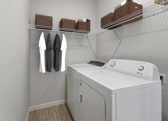a white washer and dryer in a laundry room with a rack of clothes at EastGate Apartments, Rochester, Minnesota