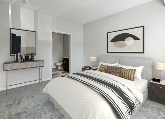 a bedroom with a bed and a desk with a mirror at EastGate Apartments, Rochester