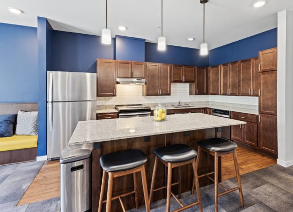 a kitchen with a large island with three stools at EastGate Apartments, Minnesota, 55904