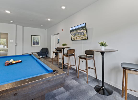 a games room with a pool table and bar with stools at EastGate Apartments, Minnesota, 55904