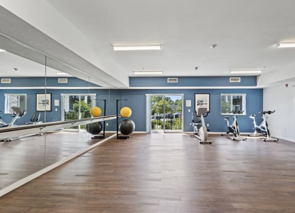 the gym with exercise equipment and mirrors at the belgard apartments at EastGate Apartments, Rochester, MN