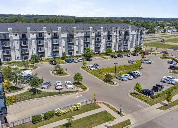 an aerial view of an apartment complex with parking lot and cars at EastGate Apartments, Rochester
