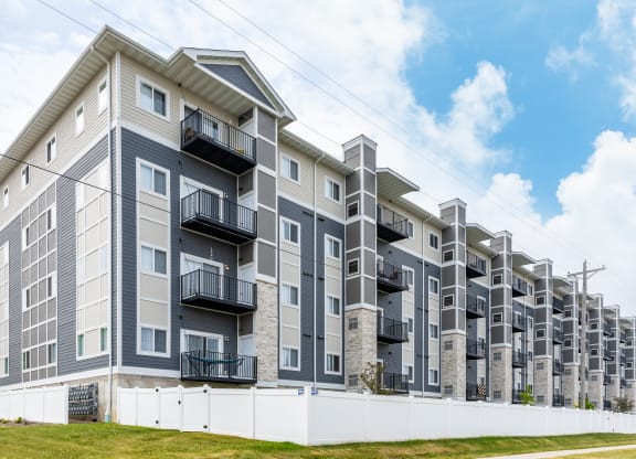 a large apartment building with balconies and a blue sky in the background at EastGate Apartments, Rochester, MN, 55904