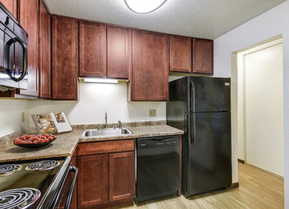 a kitchen with black appliances and wooden cabinets