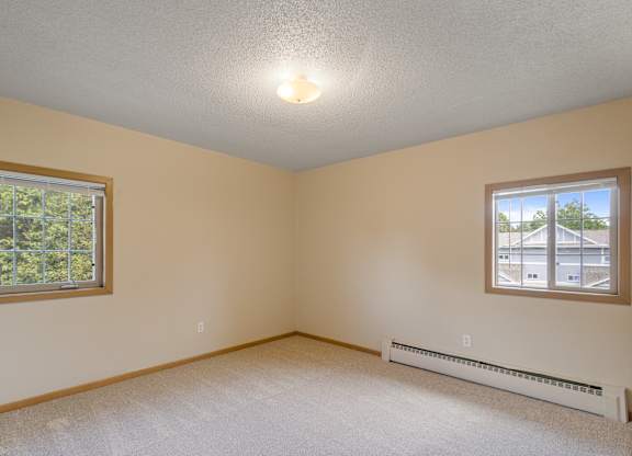 A room with a window and a wall-mounted air conditioner.