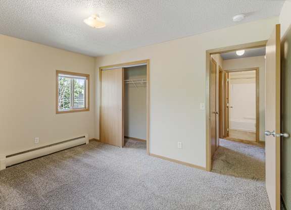 A room with a carpeted floor and a window.
