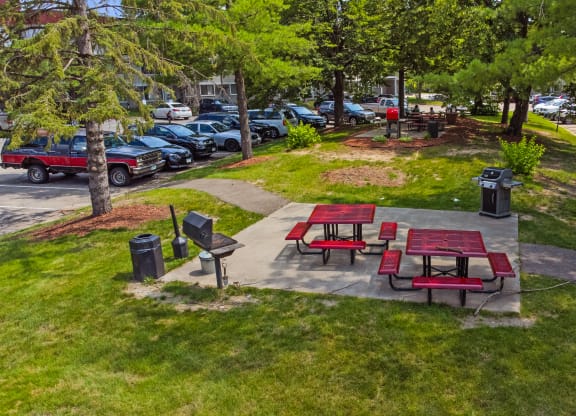 two picnic tables and benches in a park next to a parking lot at Heritage Hills Apartments, Minnesota