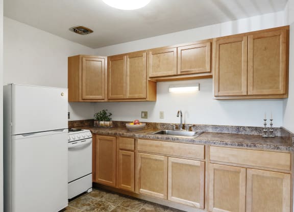 a kitchen with wooden cabinets and a white refrigerator