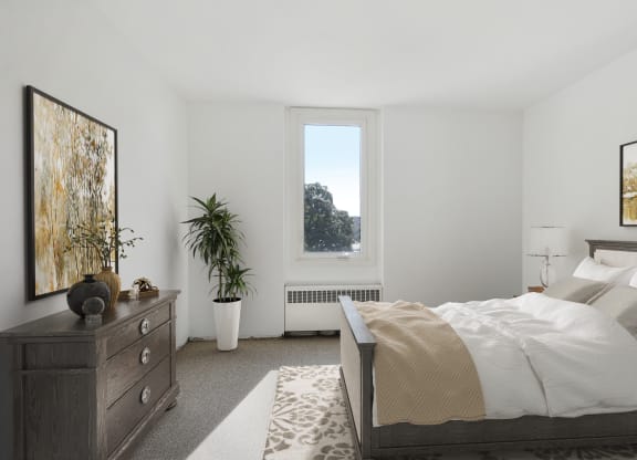 a bedroom with a bed and a dresser and a window