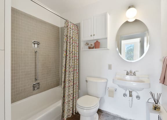 a white bathroom with a shower and a toilet and a sink