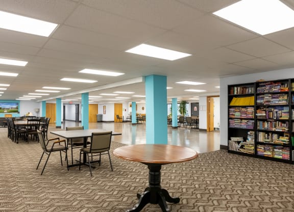 a large library with tables and chairs and bookshelves