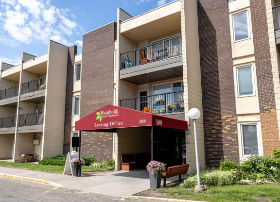 an apartment building with a red awning in front of it
