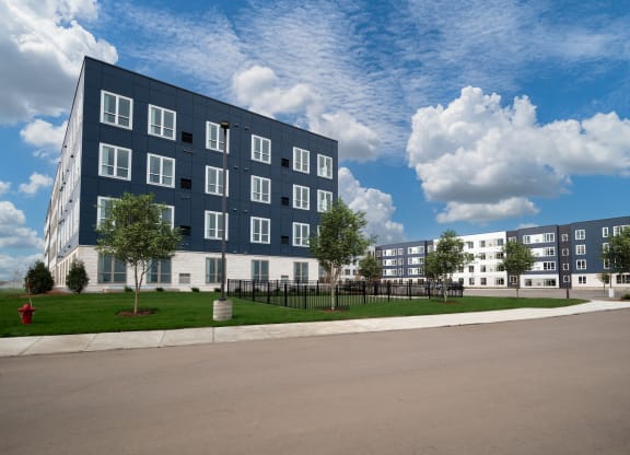 outside view of building with fenced dog park at The Landing at Amber Fields Apartments, Minnesota