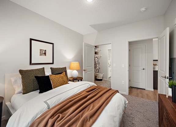a bedroom with a large bed and a bathroom at The Landing at Amber Fields Apartments, Rosemount, 55068