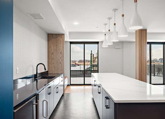 A modern kitchen with a large island and stainless steel appliances. at The Landing at Amber Fields Apartments, Minnesota, 55068