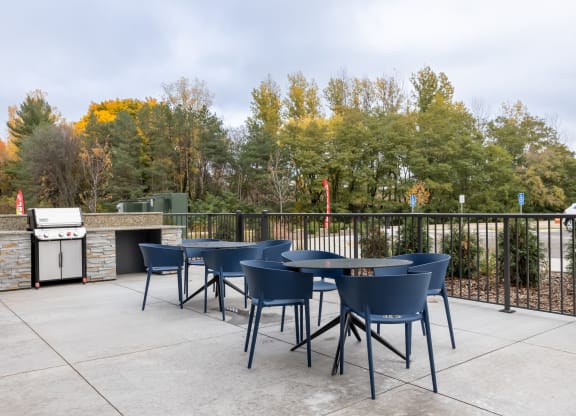 outdoor area with tables and chairs and a grill