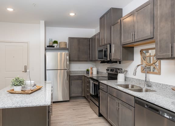 an open kitchen with stainless steel appliances and granite counter tops