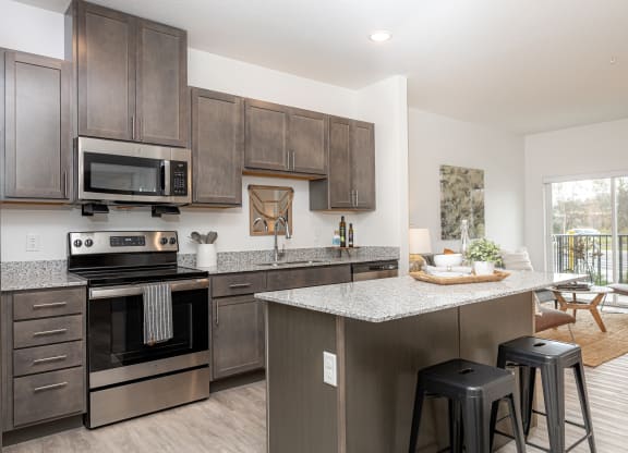 an open kitchen with stainless steel appliances and granite counter tops