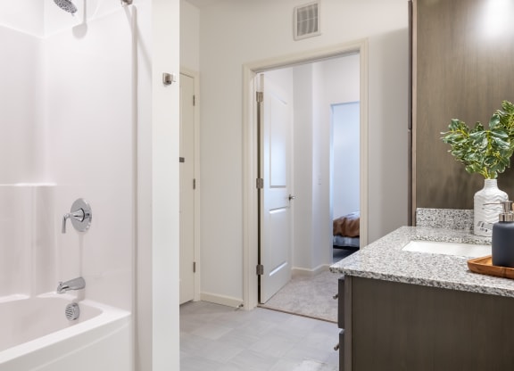a bathroom with a shower and a sink and a mirror
