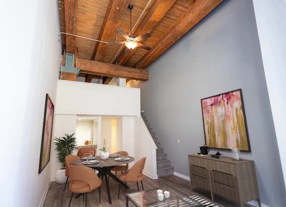 a dining room with a table and chairs and a ceiling with wooden beams