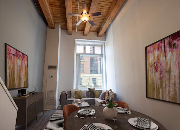 a living room with a dining room table and a ceiling fan