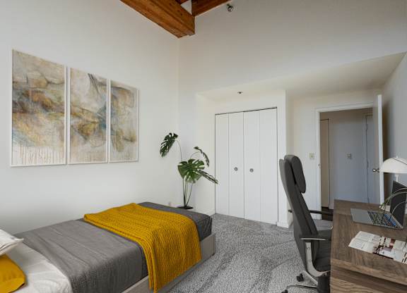 a bedroom with a bed with a yellow blanket and a desk