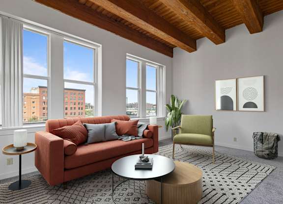 A living room with a red couch, a green chair, and a coffee table.