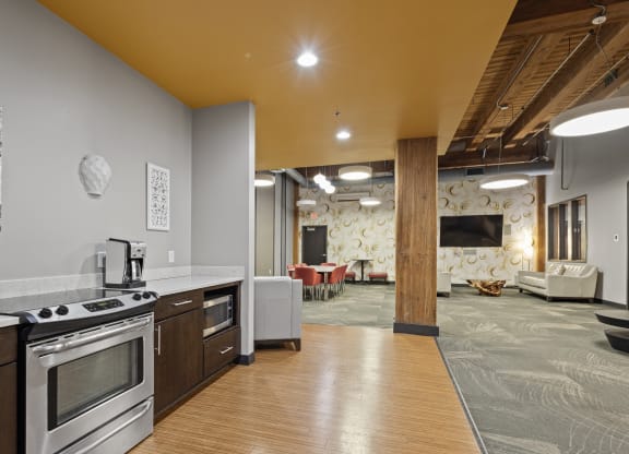 a kitchen and living room with a stove and a tv