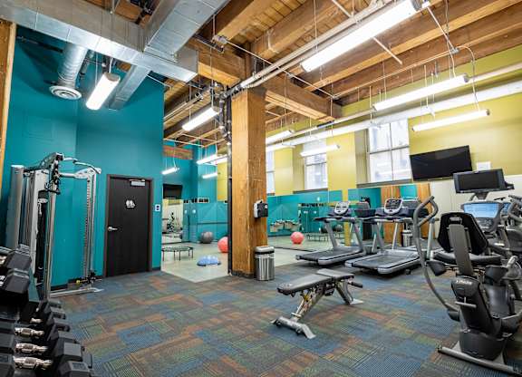 a workout room with weights and cardio equipment in a gym