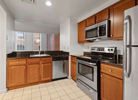 A kitchen with a black granite countertop and stainless steel appliances. at Parkside Apartments, St. Paul