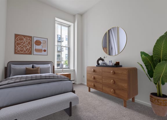 a bedroom with a bed and a dresser with a mirror