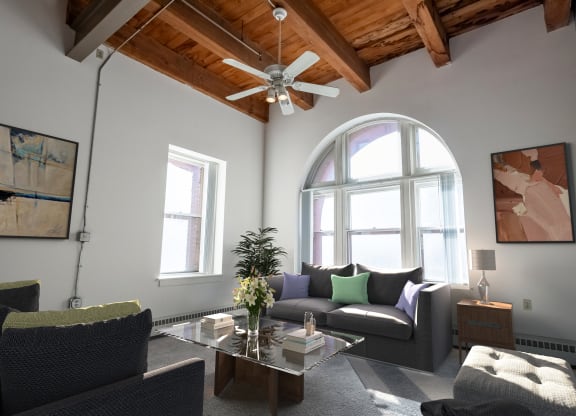 a living room with a ceiling fan and a large window