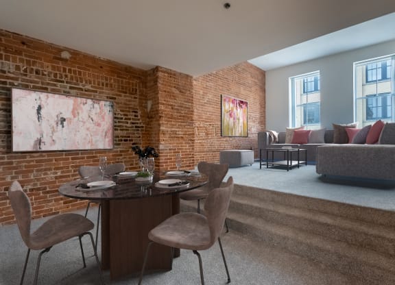 a living room with a brick wall and a table and chairs