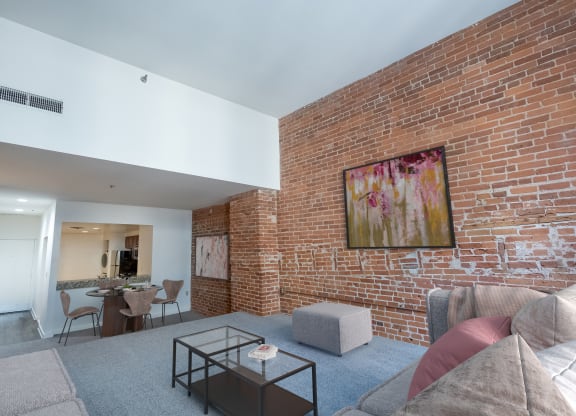 a living room with a brick wall and a couch and a coffee table