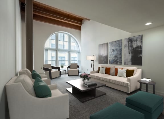 a living room with white furniture and a large arched window at Parkside Apartments, St. Paul, Minnesota