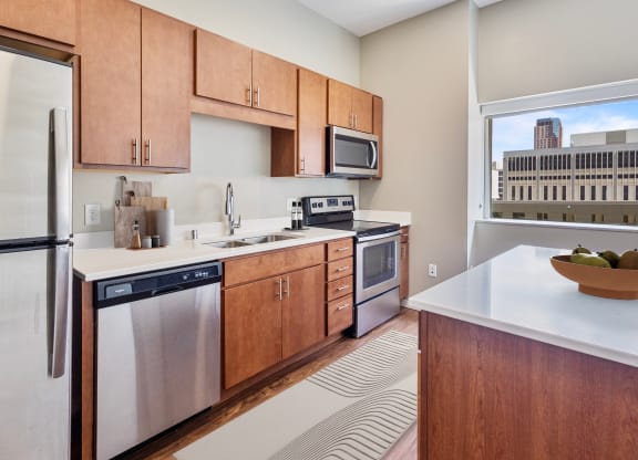 a kitchen with wooden cabinets and stainless steel appliances and a window