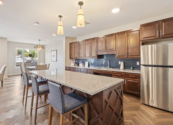 a kitchen with a large island and a stainless steel refrigerator at The Quill 55+ Apartments, Minnesota, 55033