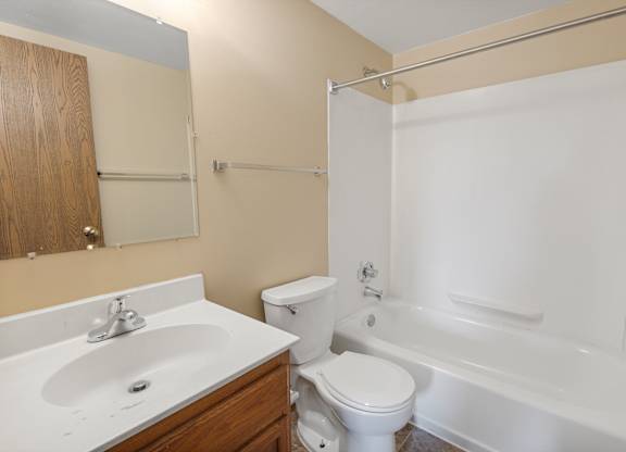 A white toilet sits next to a white sink in a bathroom.
