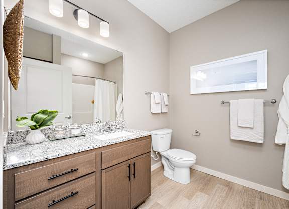 A bathroom with a white toilet and a white robe hanging on the wall.