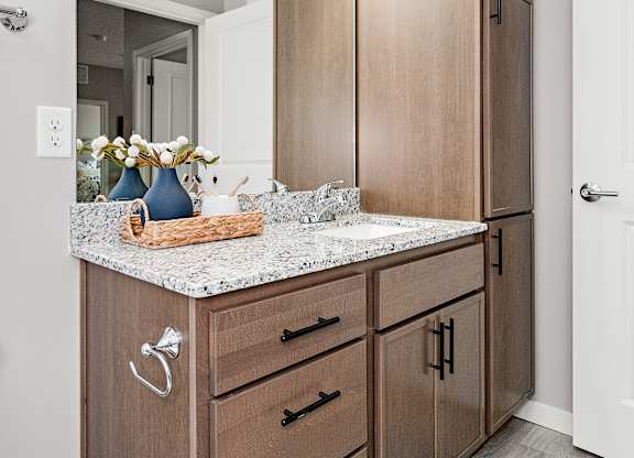 A kitchen with wooden cabinets and a marble countertop.