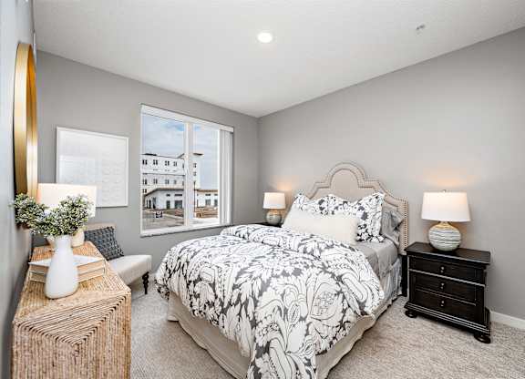 A bedroom with a large bed and a window overlooking a building.